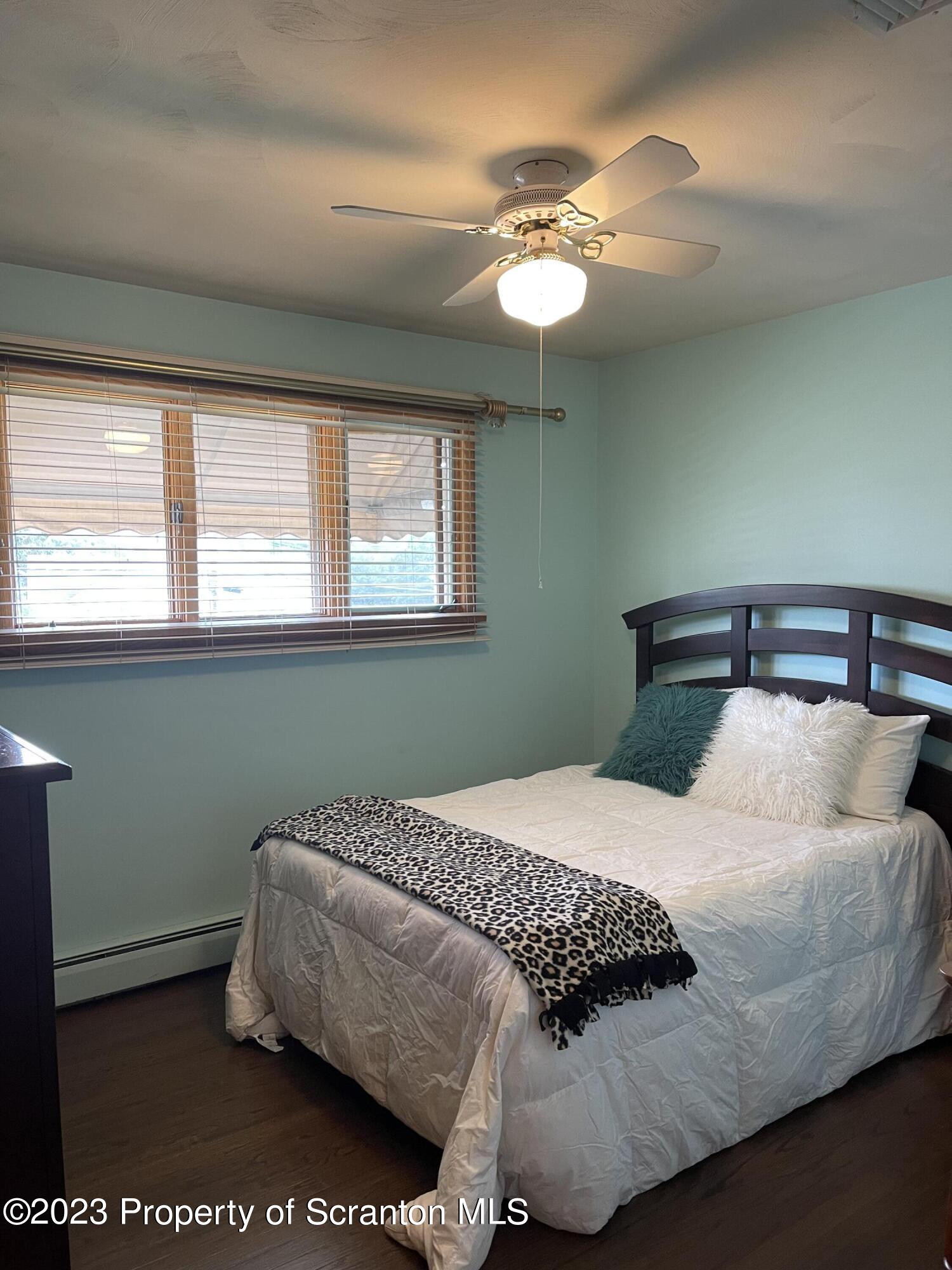 225 Main Street Olyphant, PA 18447 - Photo 35 of 60 a bedroom with a bed and chandelier