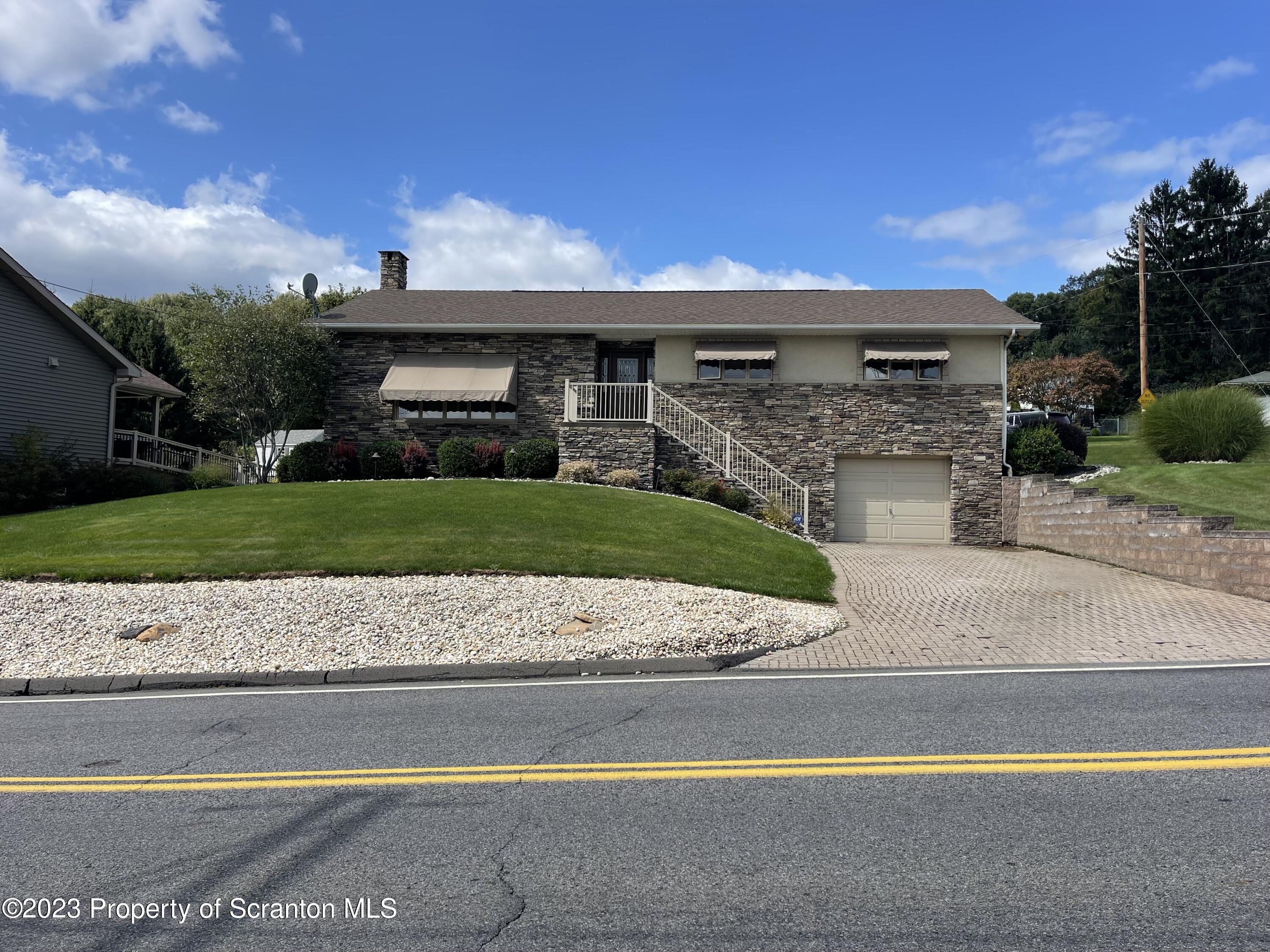 225 Main Street Olyphant, PA 18447 - Photo 4 of 60 a front view of a house with a yard and garage