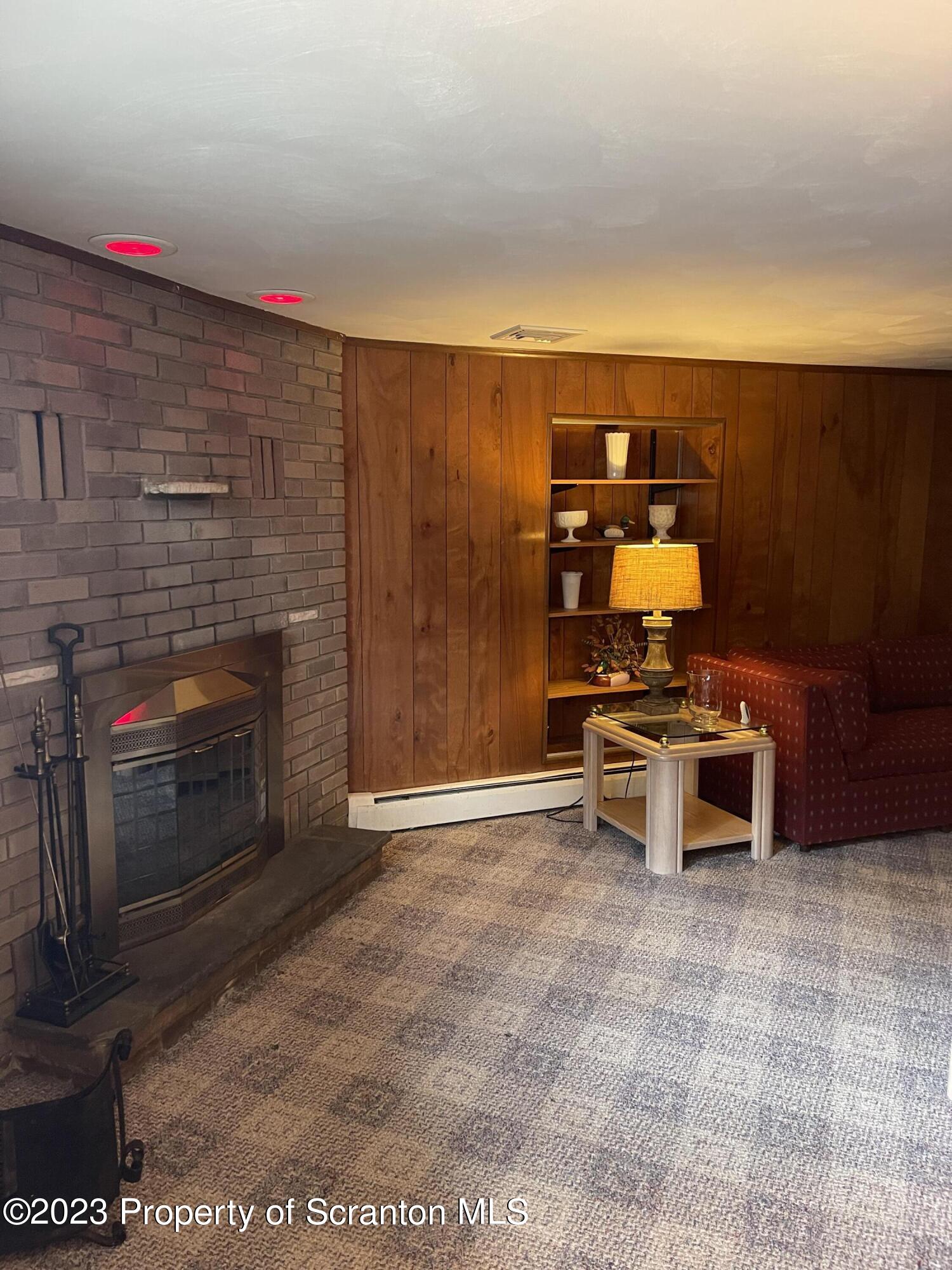 225 Main Street Olyphant, PA 18447 - Photo 47 of 60 a living room with furniture a flat screen tv and a fireplace