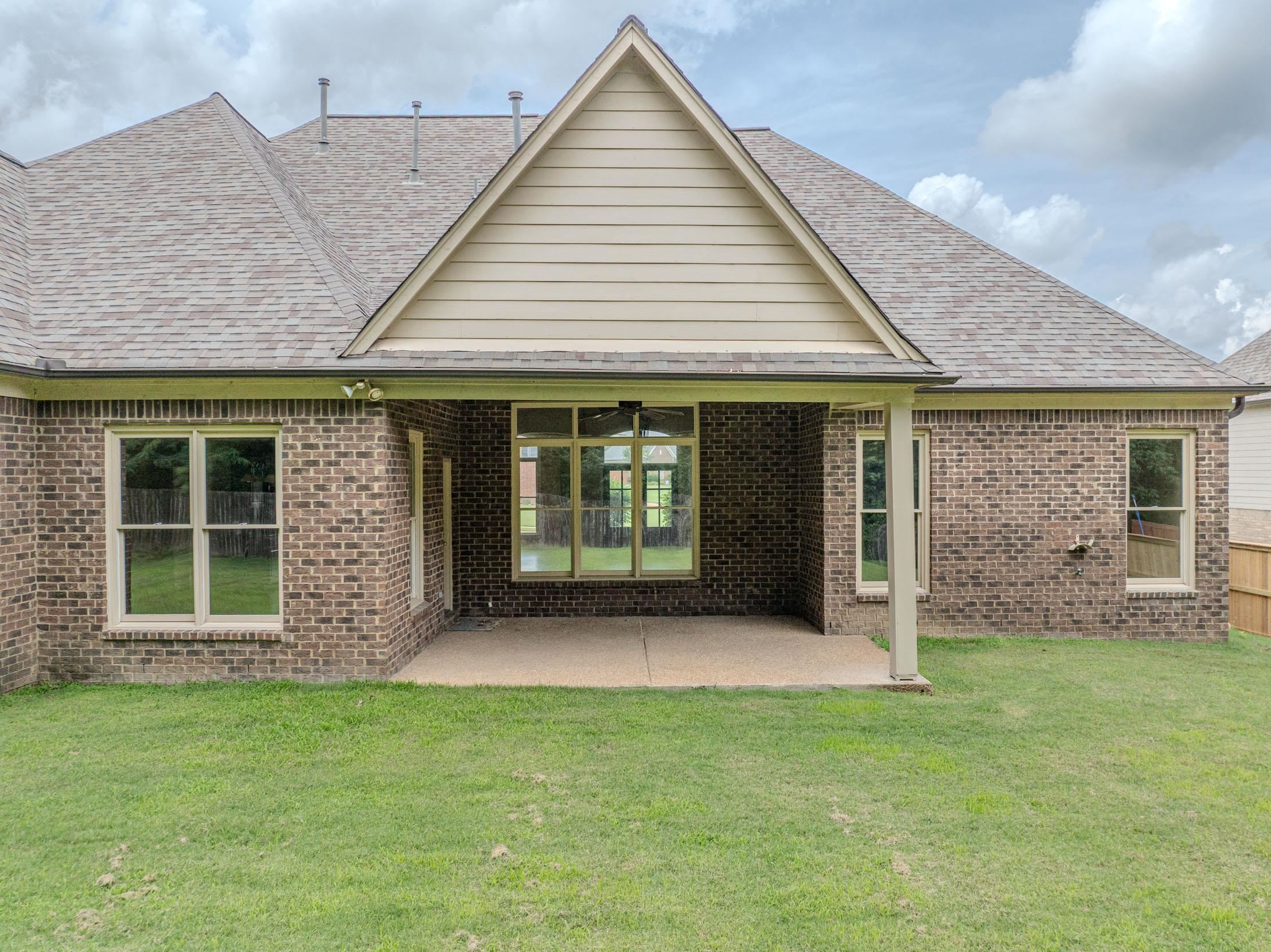 5380 Scarlet Ridge Drive Arlington, TN 38002 - Photo 30 of 35 Rear exterior featuring a covered concrete patio, brick facade, and multiple windows