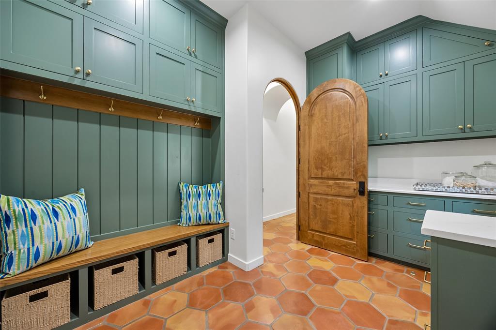 1620 Timber Ridge Lane Keller, TX 76262 - Photo 29 of 40 Rich green cabinetry, warm wood accents, terracotta tile flooring, and the arched wood door creates a stylish and inviting space that makes organization effortless