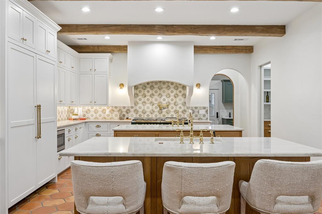 1620 Timber Ridge Lane Keller, TX 76262 - Photo 7 of 40 Dual oversized islands topped with elegant Taj Mahal quartzite countertops and custom draining grooves for both beauty and functionality