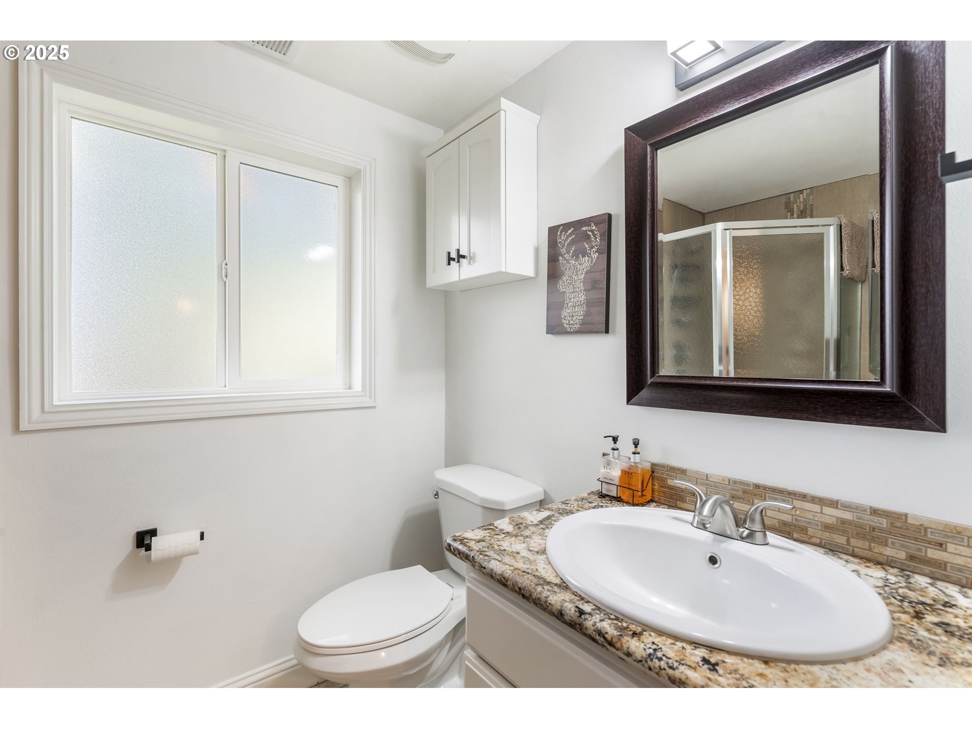 4933 Southwest 18th Place Portland, OR 97239 - Photo 28 of 43 a bathroom with a toilet a sink and mirror
