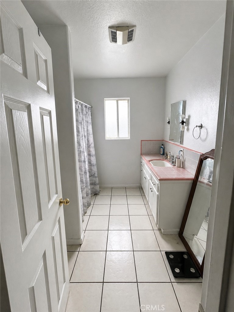 3904 Monroe Street Riverside, CA 92503 - Photo 14 of 22 a bathroom with a sink a toilet a mirror and shower