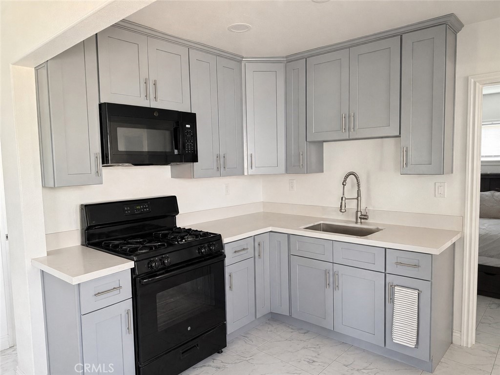 3904 Monroe Street Riverside, CA 92503 - Photo 19 of 22 a kitchen with white cabinets stainless steel appliances and sink