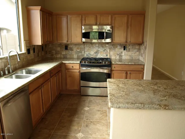 a kitchen with stainless steel appliances granite countertop a sink stove and microwave