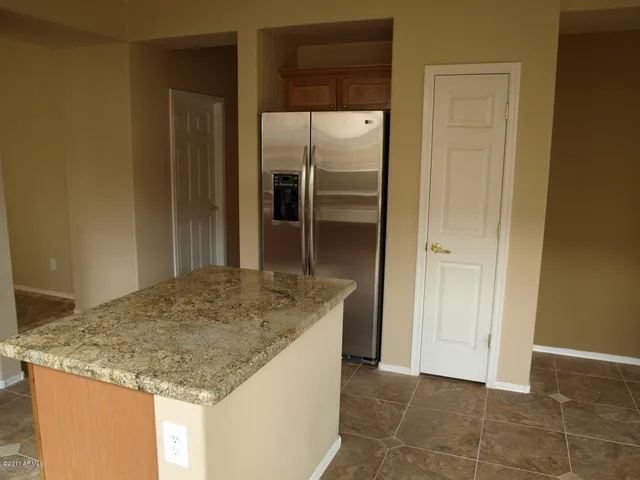 a kitchen with granite countertop a refrigerator and a sink