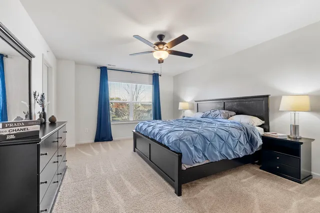 a spacious bedroom with a bed and a chandelier
