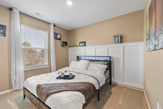 a bed sitting in a bedroom next to a window