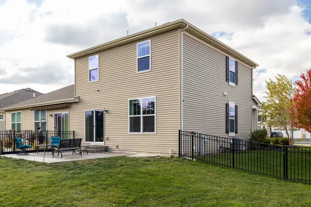 a backyard of a house with table and chairs