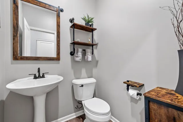 a bathroom with a toilet sink and mirror