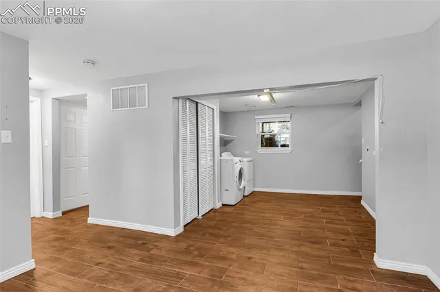 a view of a big room with wooden floor and windows