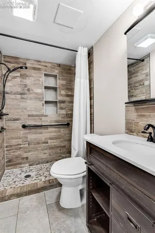 a bathroom with a sink a toilet and shower