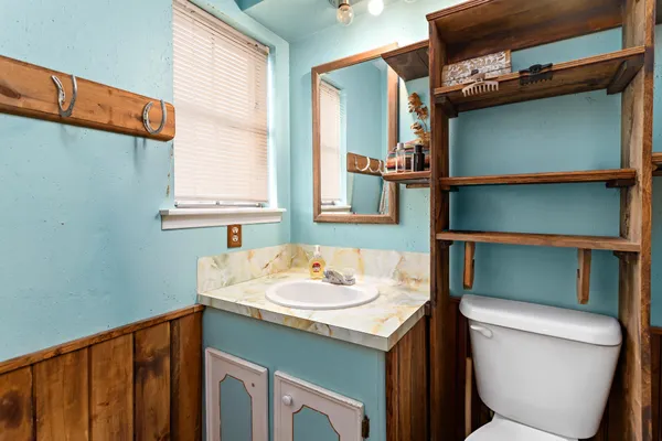 a bathroom with a toilet sink and mirror