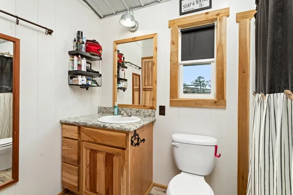 a bathroom with a toilet sink and mirror