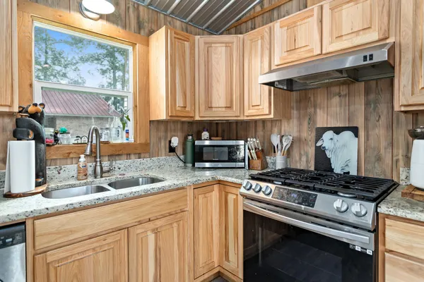 a kitchen with granite countertop a stove and a sink
