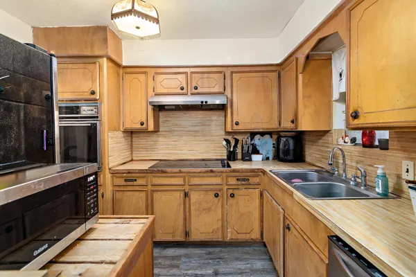 a kitchen with stainless steel appliances granite countertop a sink stove and refrigerator