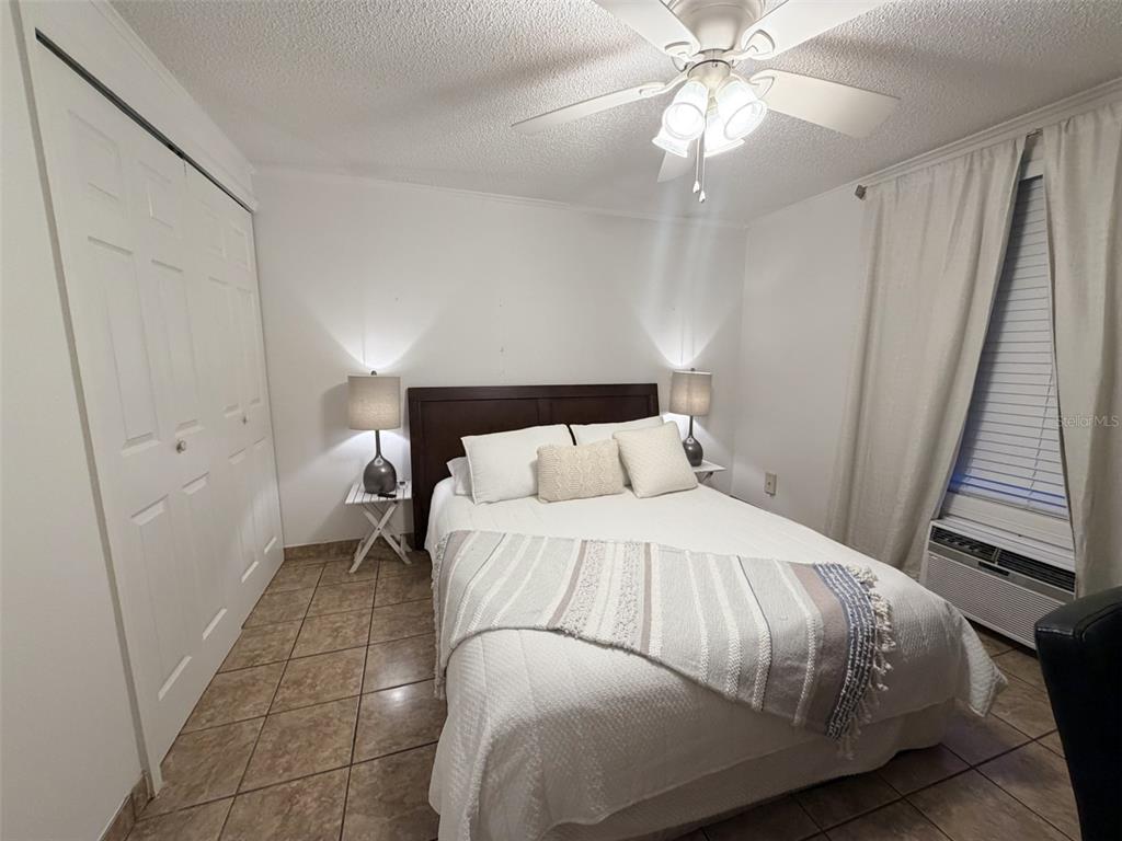 2490 Southwest 14th Drive, Unit 29 Gainesville, FL 32608 - Photo 7 of 20 a bedroom with a bed and a chandelier