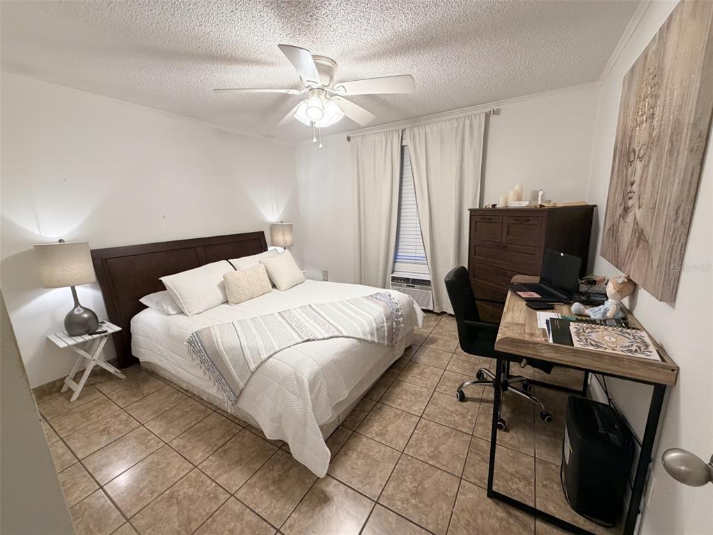 2490 Southwest 14th Drive, Unit 29 Gainesville, FL 32608 - Photo 10 of 20 a bedroom with a bed and a computer on a desk