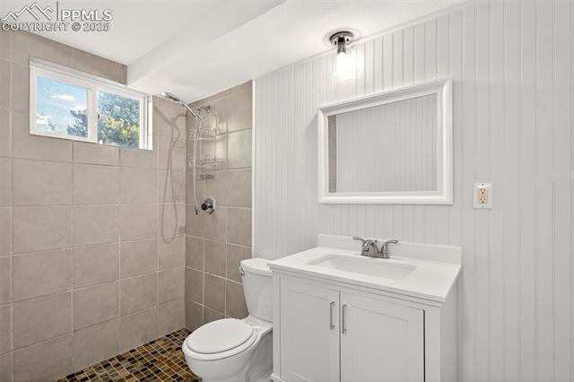 130 South Chelton Road Colorado Springs, CO 80910 - Photo 16 of 17 Bathroom featuring a tile shower, vanity, and tile patterned flooring