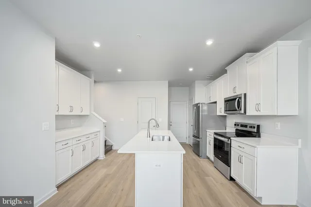 a large kitchen with stainless steel appliances granite countertop a stove and a sink
