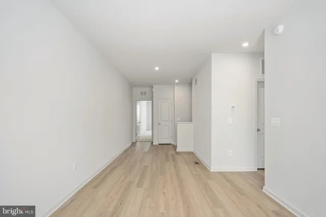 a view of a big room with wooden floor and windows