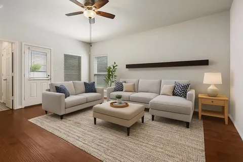 a living room with furniture and a wooden floor