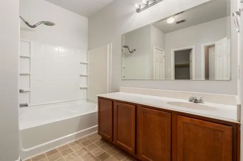 a bathroom with a tub sink and mirror