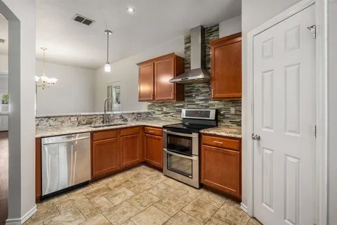 a kitchen with stainless steel appliances granite countertop a sink and a refrigerator
