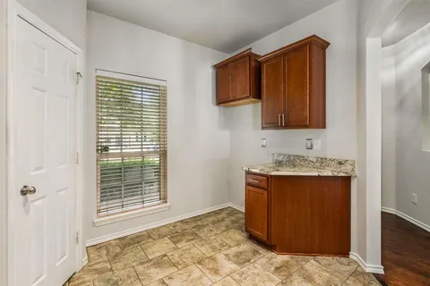 a view of kitchen with granite countertop cabinets and sink