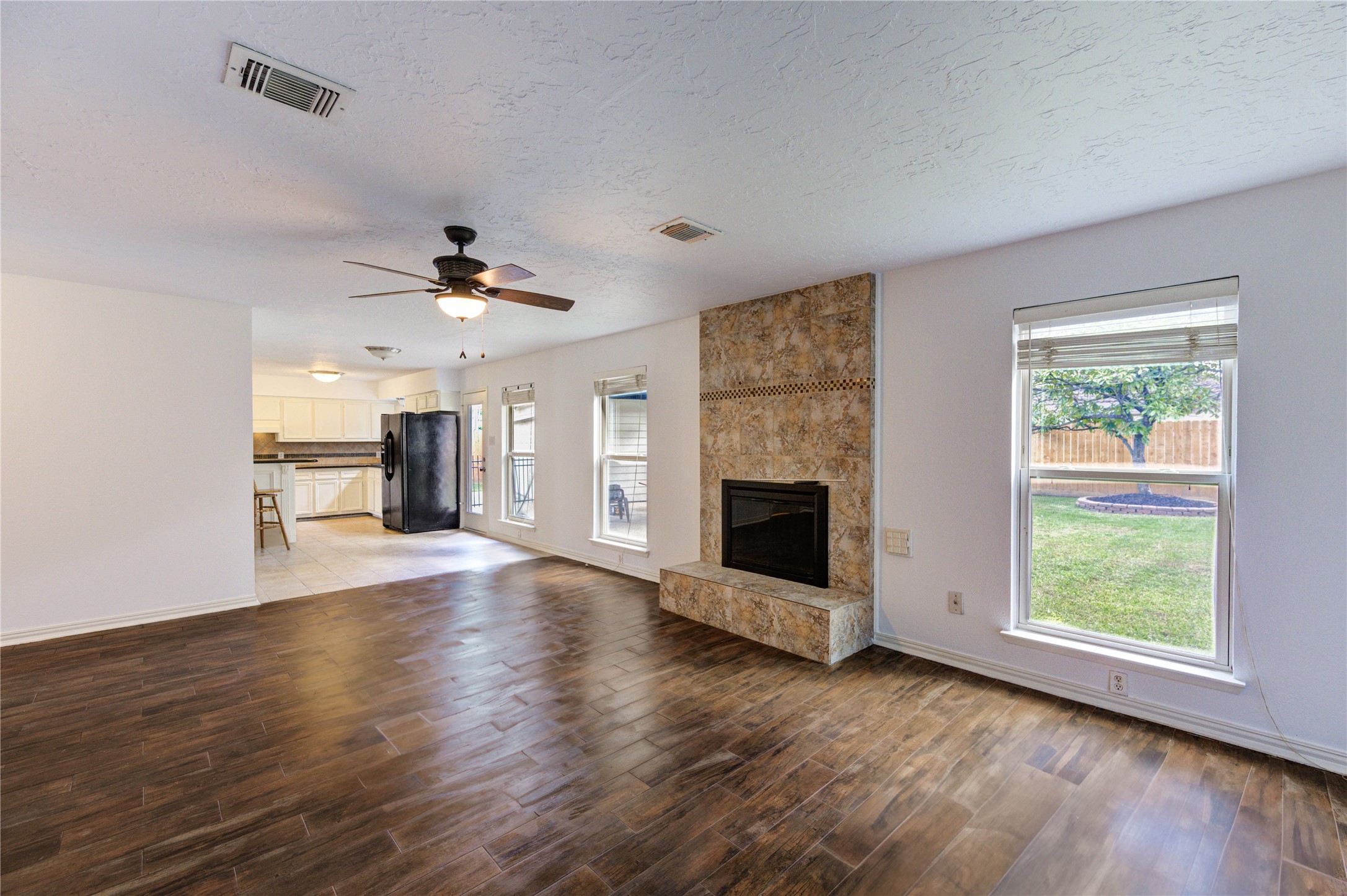3639 Fir Forest Drive Spring, TX 77388 - Photo 14 of 44 an empty room with windows fireplace and a kitchen view