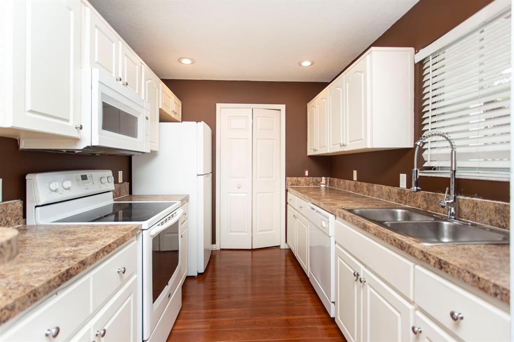 6740 Moonglow Drive, Unit 101 Port Richey, FL 34668 - Photo 14 of 39 a kitchen with stainless steel appliances granite countertop a sink stove and refrigerator
