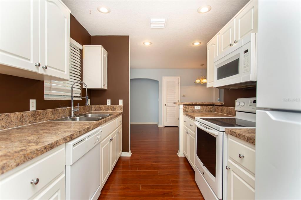 6740 Moonglow Drive, Unit 101 Port Richey, FL 34668 - Photo 16 of 39 a kitchen with stainless steel appliances granite countertop a sink and a stove
