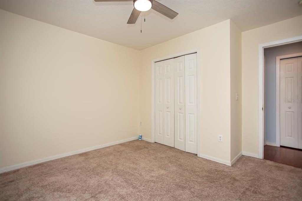 6740 Moonglow Drive, Unit 101 Port Richey, FL 34668 - Photo 22 of 39 an empty room with a chandelier fan