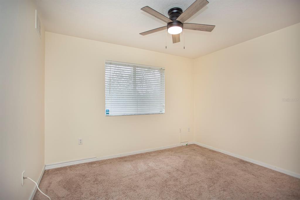 6740 Moonglow Drive, Unit 101 Port Richey, FL 34668 - Photo 23 of 39 an empty room with a window and a fan