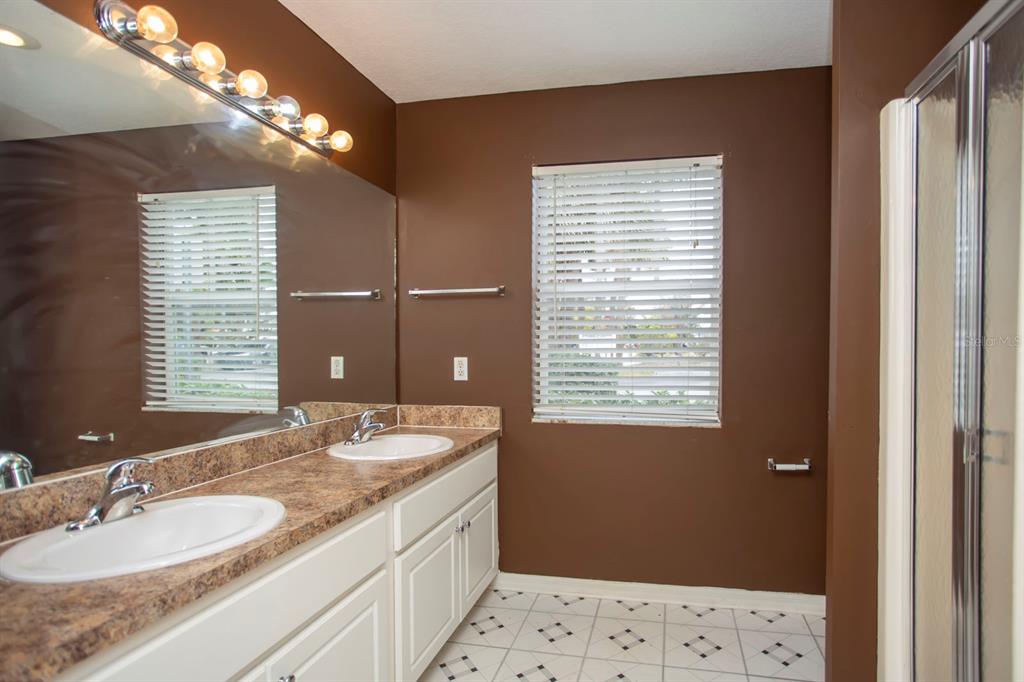 6740 Moonglow Drive, Unit 101 Port Richey, FL 34668 - Photo 29 of 39 a bathroom with a double vanity sink and a mirror