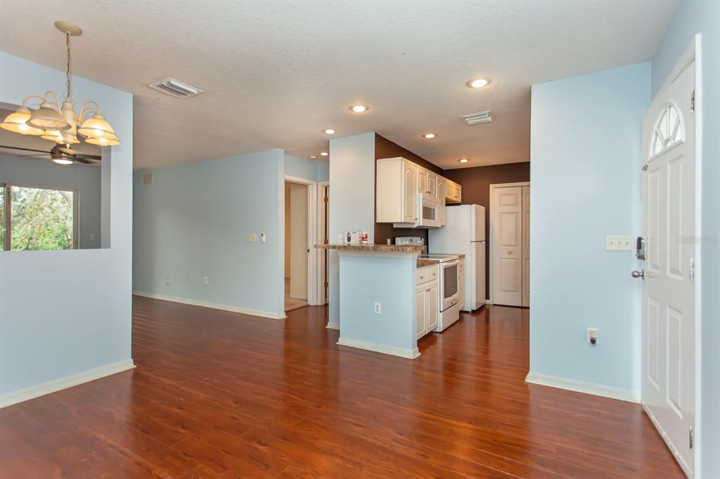 6740 Moonglow Drive, Unit 101 Port Richey, FL 34668 - Photo 8 of 39 a view of a kitchen with wooden floor and a refrigerator