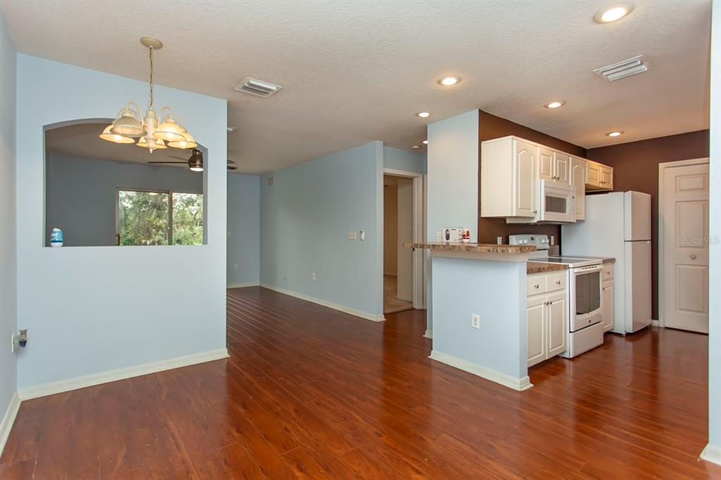 6740 Moonglow Drive, Unit 101 Port Richey, FL 34668 - Photo 9 of 39 a view of a kitchen with wooden floor and stainless steel appliances