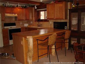 199 Sheep Ridge Road Fairplay, CO 80440 - Photo 3 of 16 a kitchen with a table chairs and a refrigerator