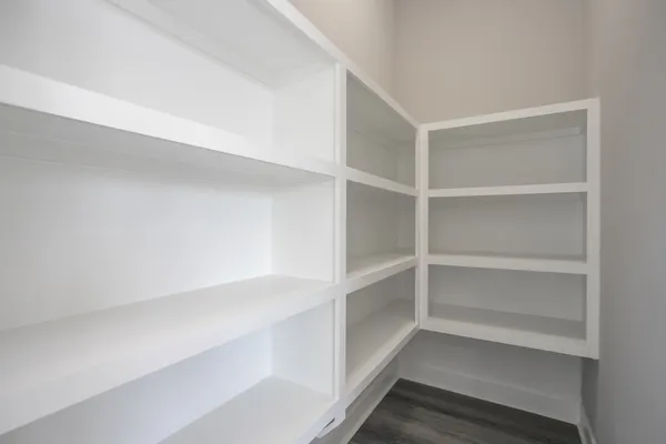 a view of walk in closet with empty racks