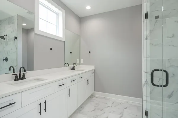 a bathroom with a double vanity sink mirror and window