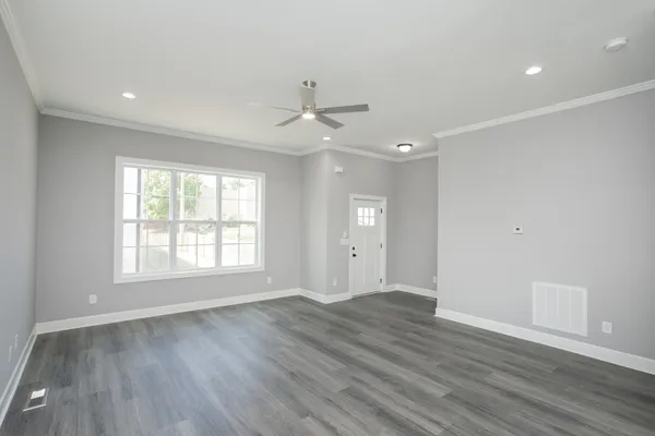 an empty room with wooden floor and windows