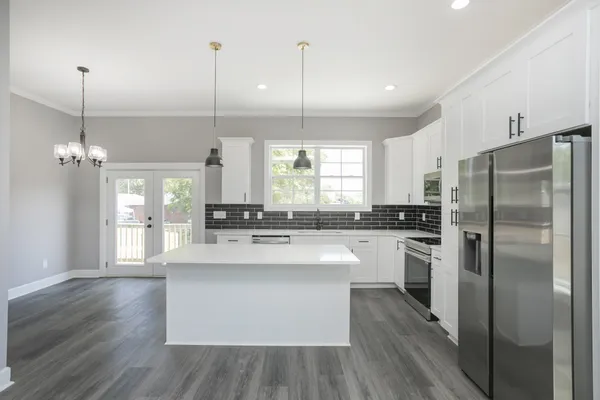 a kitchen with kitchen island white cabinets and stainless steel appliances