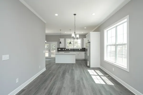 a large kitchen with hardwood floor a window and stainless steel appliances