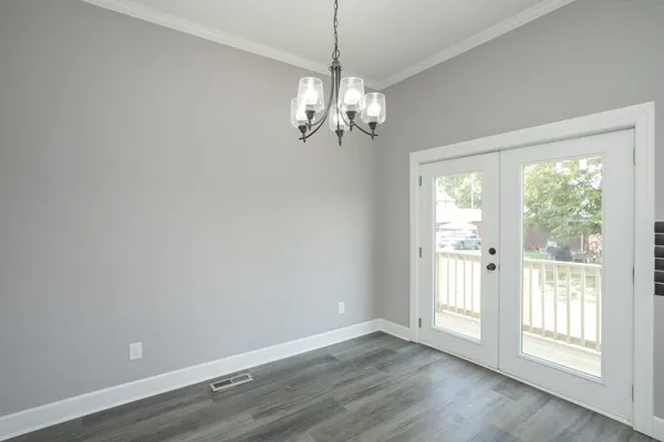 a view of empty room with wooden floor and window