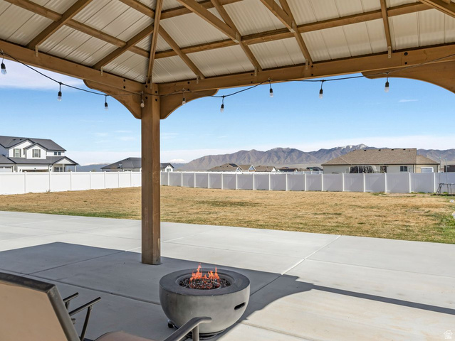 573 South Maxwell Drive Grantsville, UT 84029 - Photo 21 of 25 Fenced backyard with a patio area, a mountain view, and a fire pit