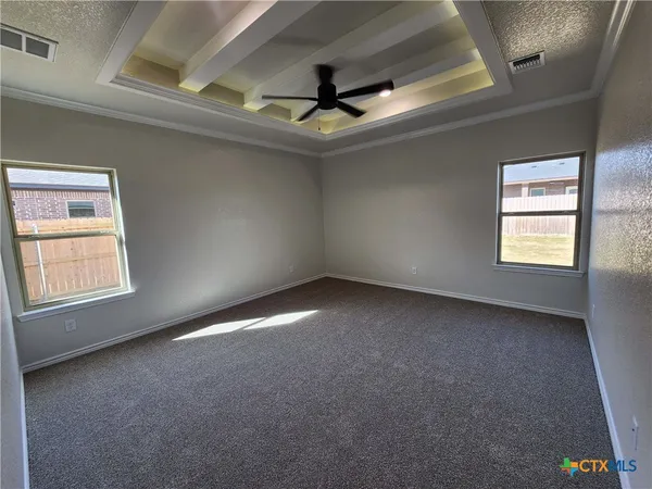 an empty room with a ceiling fan and window