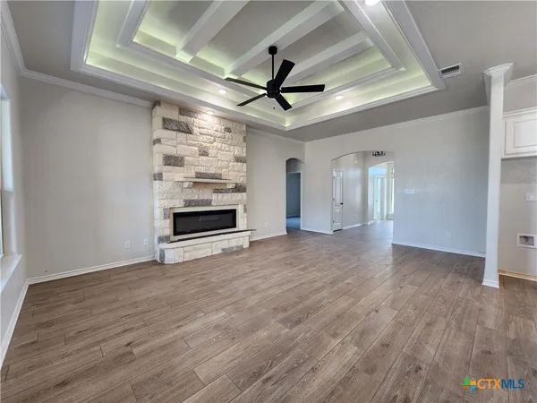 a view of an empty room with a window and wooden floor