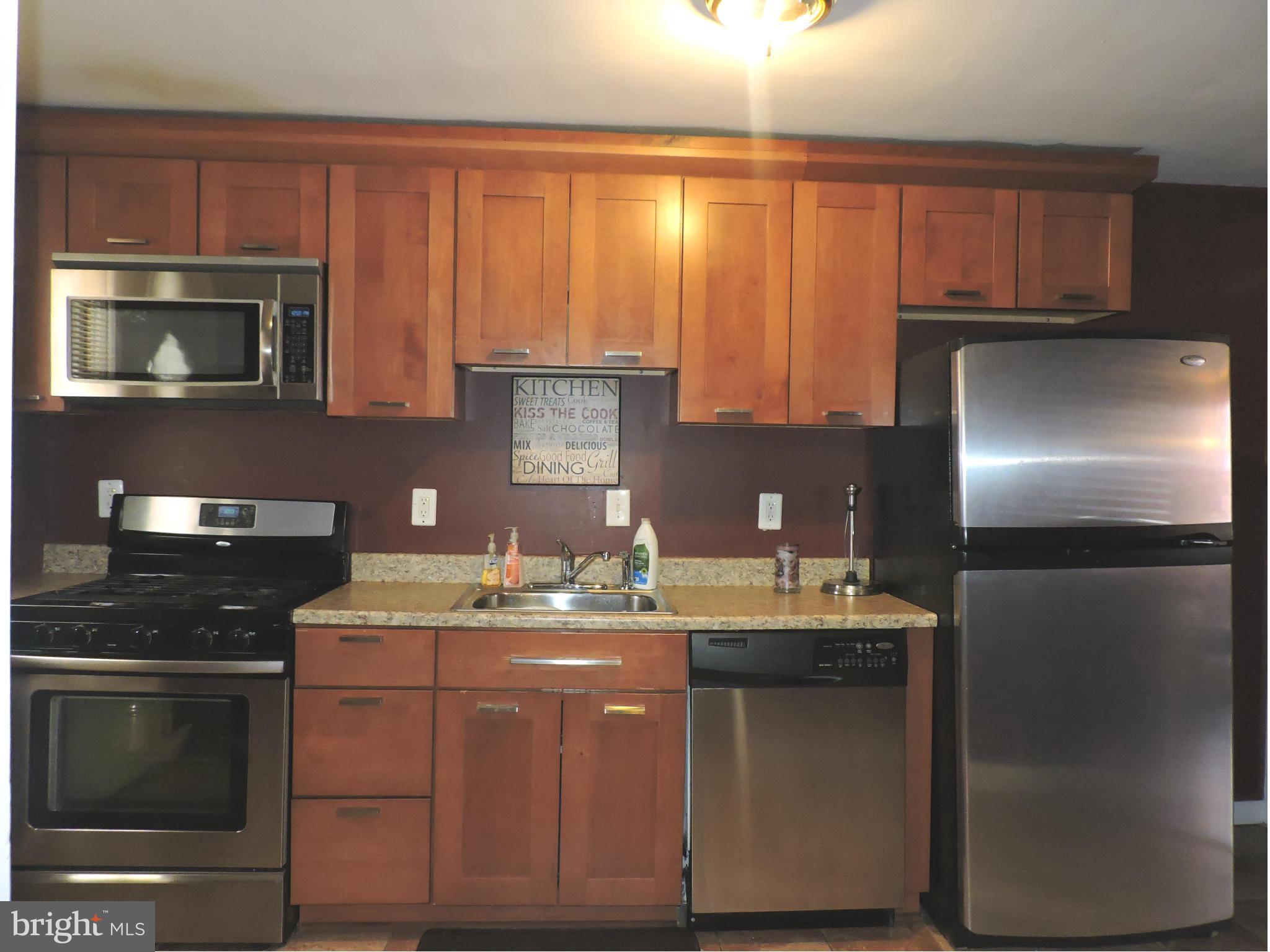 1218 Kevin Road Baltimore, MD 21229 - Photo 8 of 27 a kitchen with stainless steel appliances granite countertop a sink stove and microwave