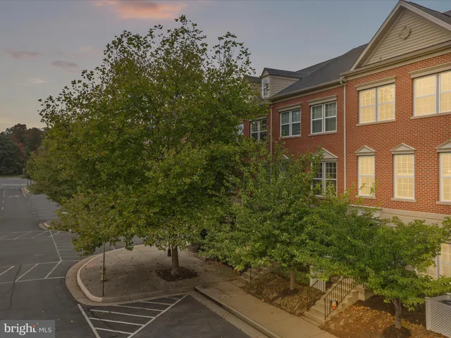 a couple of potted plants in front of brick house